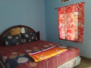 a bedroom with a bed with a blanket on it at Sawe Homestay in Kuta Lombok