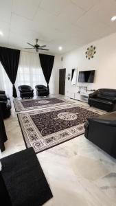 - un salon avec un canapé et un tapis dans l'établissement PD Best Homestay, à Port Dickson