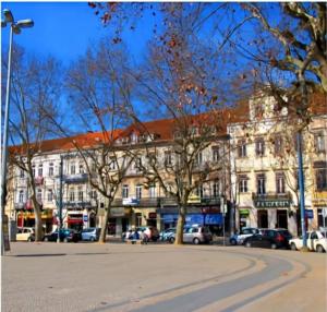 un grand bâtiment avec des voitures garées devant lui dans l'établissement Carla D., à Coimbra