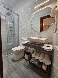 y baño con lavabo, aseo y espejo. en Fotini's Apartments - Pelekas Beach, en Pelekas