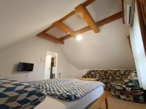 a bedroom with a bed and a couch at Katerina Vendégház in Tihany
