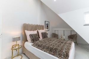 ein Schlafzimmer mit einem großen Bett mit rosa Kissen in der Unterkunft LUXXLOFT Luxusapartments Wetzlar in Wetzlar