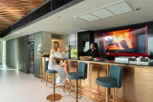 two women sitting at a bar in a kitchen at Villa W Luxury in Nai Harn Beach +33 photos