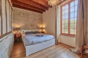 a bedroom with a bed and a large window at Le Moutou - Maison avec piscine in Tombeboeuf +16 photos