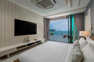 a hotel room with a bed and a large window at Villa W Luxury in Nai Harn Beach