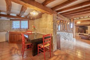 a kitchen with a table and chairs and a fireplace at Le Moutou - Maison avec piscine in Tombeboeuf
