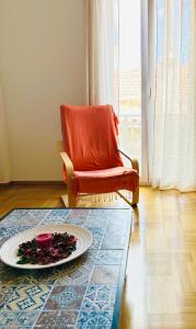 een woonkamer met een stoel en een bord op een tapijt bij Bella Vista Apartment in Chios