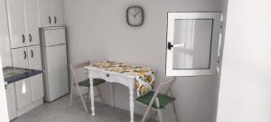 a kitchen with a table and two chairs and a clock at Divertida y Romántica in Pegalajar