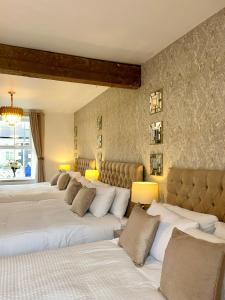 - une rangée de lits dans une chambre avec un mur dans l'établissement Fitzgeralds - Ballybunion - Sleeps 34, à Ballybunion