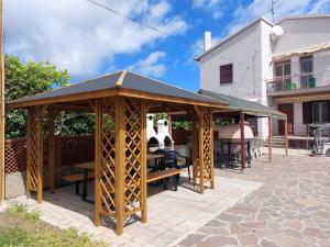 a gazebo with wooden tables and benches on a patio at Appartamenti L'Arcipelago in Marina di Campo