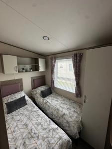 two beds in a small room with a window at New beach holiday park in Dymchurch +17 photos