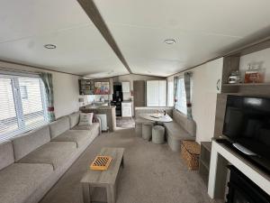 a living room with a couch and a tv at New beach holiday park in Dymchurch