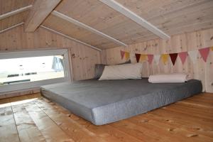 1 dormitorio con 1 cama en una habitación con ventana en Ferienhaus "Deichglück" direkt an der Nordsee 2023 saniert, en Wesselburenerkoog