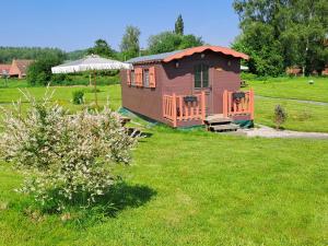 une petite cabine au milieu d'une pelouse dans l'établissement Monts de flandre insolite, à Berthen