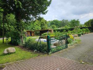 een groene poort in een tuin met een huis bij Ferienwohnung 1 Am Park in Divitz