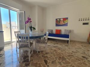- une salle à manger avec une table, des chaises et un canapé dans l'établissement Angolo del Mare - Case Libeccio e Blu Marino, à Favignana