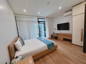 a bedroom with a bed and a flat screen tv at Queen Hotel Hoàng Gia in Thái Nguyên