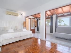 a white bedroom with two beds and a couch at Ca sa Padrina in Colonia Sant Jordi +26 photos