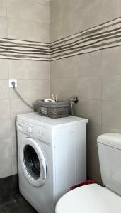 een wasmachine in een badkamer met een toilet bij Bella Vista Apartment in Chios