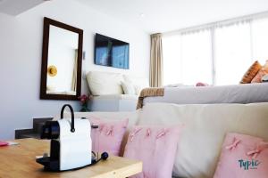 a living room with a white couch and pink pillows at Marina Playa Hotel Apartments by Typic Hotels - Adults Only in San Antonio Bay