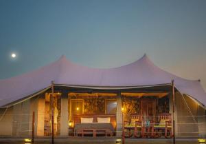 een grote tent met een bed in de nacht bij Alama Camp Mara in Ololaimutiek