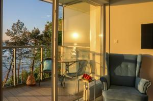 Zimmer mit einem Balkon mit einem Stuhl und einem Tisch in der Unterkunft Apartament z widokiem na morze- USTRONIE APARTMENTS Nadmorski Luksus Apartamenty in Ustronie Morskie