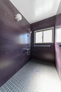 baño con ducha y puerta de cristal en Residence Hotel Kamoike, en Kagoshima