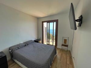 een slaapkamer met een bed en een flatscreen-tv bij Apartamento 1ª linea de mar in Platja  d'Aro