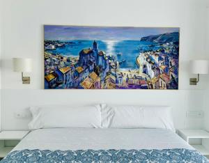 un cuadro sobre una cama en un dormitorio en Hostal Marina Cadaqués, en Cadaqués