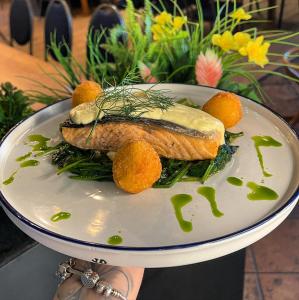 a plate of food with a piece of fish and oranges at Hotel Miodowy in Dzierżoniów