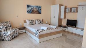 - une chambre avec un lit, une chaise et une télévision dans l'établissement Olympia Beach Complex, à Ravda
