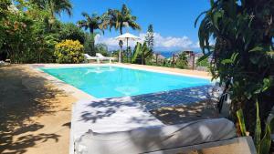 una piscina en un patio con mesa y sillas en Villa Razambe, en Nosy Be