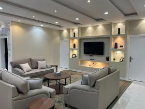 a living room with couches and a flat screen tv at مسكن الفخامة in Taif