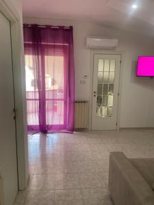 a living room with pink curtains and a couch at Alcione113 Apartment in Francavilla al Mare
