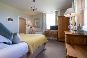 a bedroom with a bed and a desk and a television at Hassop Station Apartment on the Monsal Trail in Bakewell