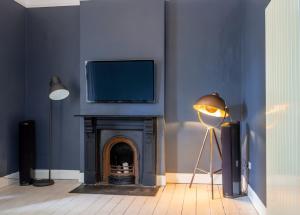 a living room with a fireplace with a tv above it at GuestReady - Luxurious Ballsbridge house in Dublin +41 photos