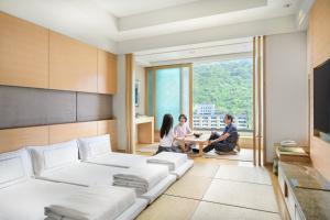 un grupo de personas sentadas en una sala de estar en Evergreen Resort Hotel - Jiaosi, en Jiaoxi