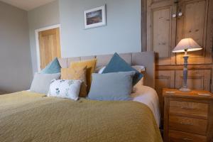 a bedroom with a bed with blue and yellow pillows at Hassop Station Apartment on the Monsal Trail in Bakewell