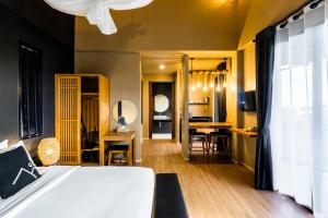 Schlafzimmer mit einem Bett und einem Schreibtisch mit Stühlen in der Unterkunft The Mangrove Phuket by Blu Monkey in Panwa Beach