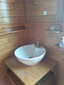 a bathroom with a white bowl sink on a wooden table at Monts de flandre insolite in Berthen