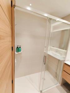 La salle de bains est pourvue d'une douche avec une porte en verre. dans l'établissement L'Eixideta, à Salou