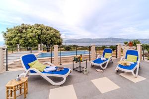 a patio with three chairs and a table and a pool at Holiday home Horizont in Supetar