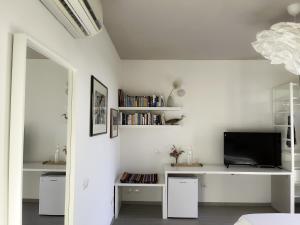 里奥托尔托Le Dimore Rosse - Agriturismo的客厅配有电视和白色墙壁。