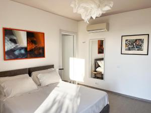 里奥托尔托Le Dimore Rosse - Agriturismo的一间带床和枝形吊灯的白色卧室
