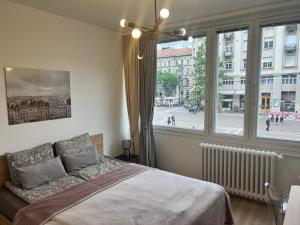 a bedroom with a bed and a large window at Bazilika View in Budapest