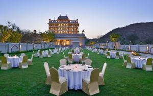 a group of tables and chairs in front of a building at Indana Palace Jaipur in Jaipur