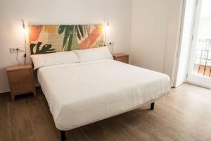 sypialnia z białym łóżkiem i 2 szafkami nocnymi w obiekcie Torre Solana 41 w Kadyksie
