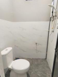 W łazience znajduje się biała toaleta i prysznic. w obiekcie Paddy Villea Inn SPT Penang w mieście Permatang Pauh