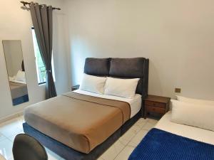 Paddy Villea Inn SPT Penang في Permatang Pauh: غرفة نوم مع سرير مع اللوح الأمامي ومرآة