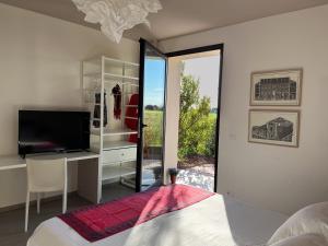 里奥托尔托Le Dimore Rosse - Agriturismo的一间带床、电视和窗户的卧室